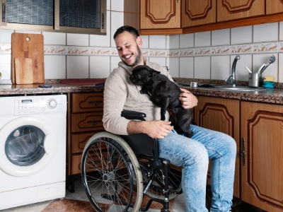 accessible-kitchen-massachusetts A happy man in a wheelchair holding a puppy in a well remodeled accessible kitchen.