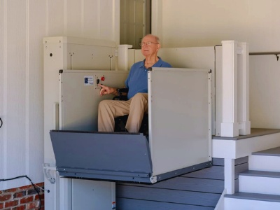 An elderly man in a wheelchair lifts on the accessible lift.