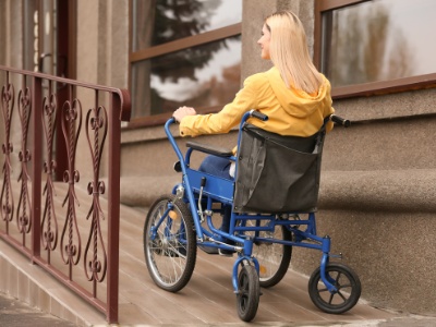 A woman in a wheelchair rides on the ramp.
